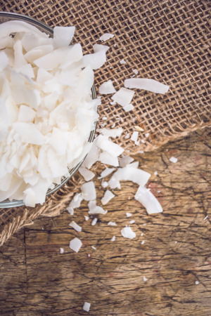 Dried coconut flakes on wooden backgroundの写真素材