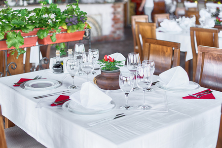 Glasses and plates on table in restaurantの写真素材