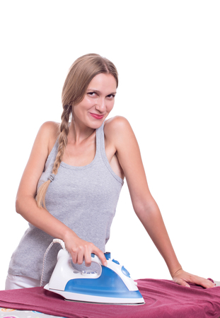 Smiling young woman ironing clothesの写真素材
