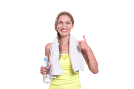 Young gym woman with water bottle smiling isolated on whiteの写真素材
