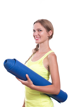 Fitness woman ready for workout, holding yoga mat isolated on white backgroundの写真素材