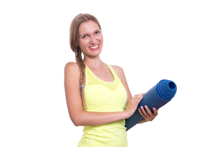 Fitness woman ready for workout, holding yoga mat isolated on white backgroundの写真素材
