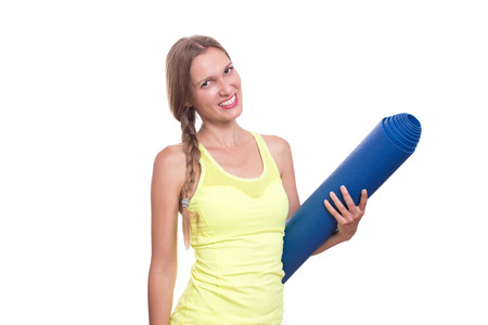 Fitness woman ready for workout, holding yoga mat isolated on white backgroundの写真素材