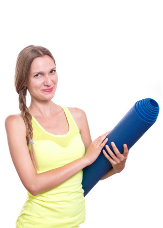 Fitness woman ready for workout, holding yoga mat isolated on white backgroundの写真素材