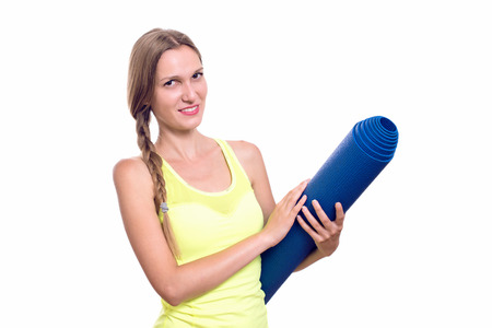 Fitness woman ready for workout, holding yoga mat isolated on white backgroundの写真素材