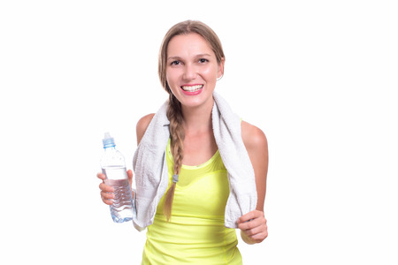 Young gym woman with water bottle smiling isolated on whiteの写真素材