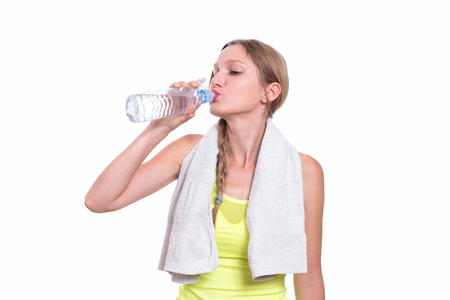 Sporty woman drinking water, isolated on white backgroundの写真素材