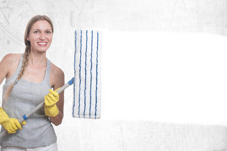 Happy woman in gloves cleaning windowの写真素材