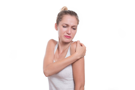 Acute pain in a woman shoulder. Female holding hand to spot of shoulder-achesの写真素材
