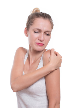 Acute pain in a woman shoulder. Female holding hand to spot of shoulder-achesの写真素材