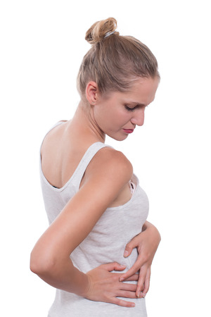 Young female touching right side of body in pain.  Kidney pain. Isolated on white backgroundの写真素材