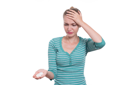 Unhappy woman holding painkillers, isolated on white backgroundの写真素材