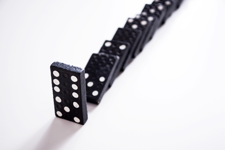 Dominoes - row of black dominoes on whiteの写真素材