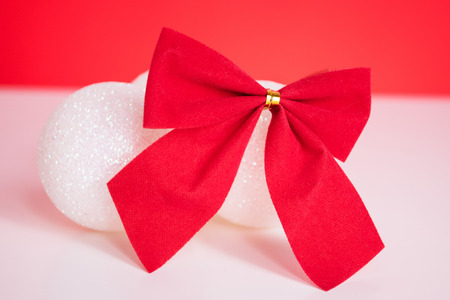 Christmas balls and red ribbon on red backgroundの写真素材