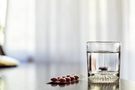 full glass of water with medicationの写真素材