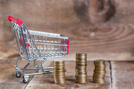 Saving and shopping concept. Coins in shopping cartの写真素材