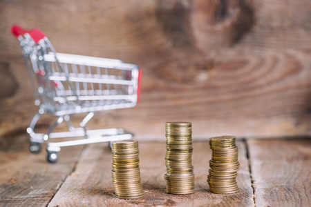 Saving and shopping concept. Coins in shopping cartの写真素材
