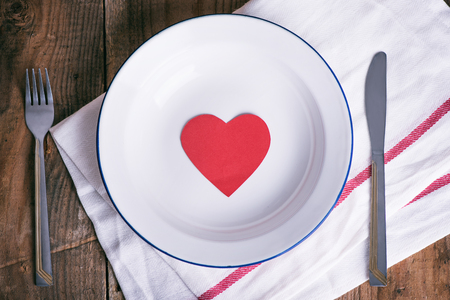 Concept diet and weight loss. Empty plate with red paper heart in the middle of the plateの写真素材
