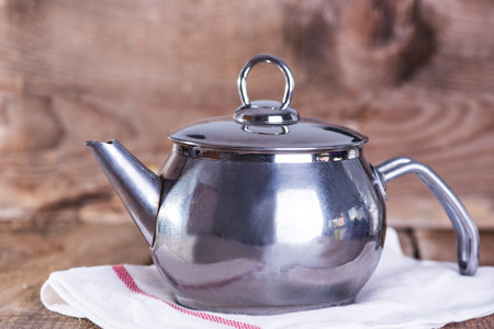 Metal tea pot on wooden backgroundの写真素材