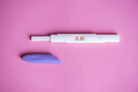 Positive pregnancy test on pink backgroundの写真素材