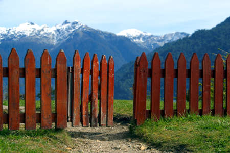 FENCE HALF OPEN IN THE TOP OF THE HILL WITH VIEWS TO THE MOUNTAINSの写真素材