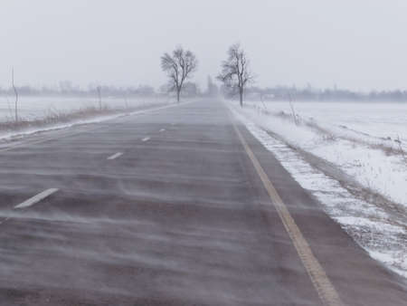 Road under the blizzard, snowstorm in winterの写真素材