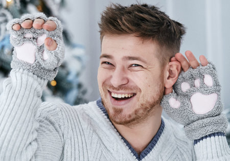 Nice boy wearing gloves with cats paws and smiling