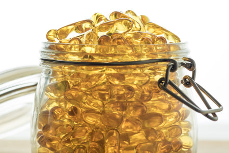 Omega 3-6-9 fish oil yellow softgels into airtight glass jarの写真素材
