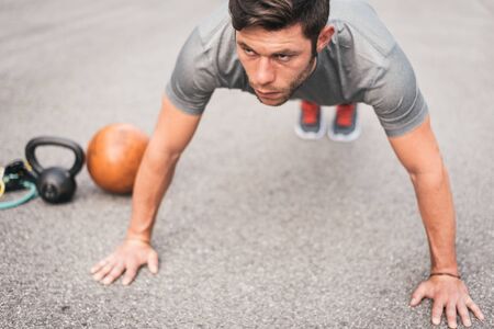 urban fitness man doing push ups workout outdoor on asphaltの写真素材