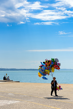 Thessaloniki, Greece - April 14, 2017 : Woman with colorful balloons for sale walking along Thessaloniki seafrontのeditorial素材