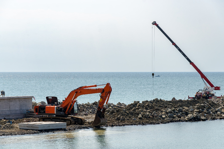 Crane and excavator building new quay in the seaの写真素材