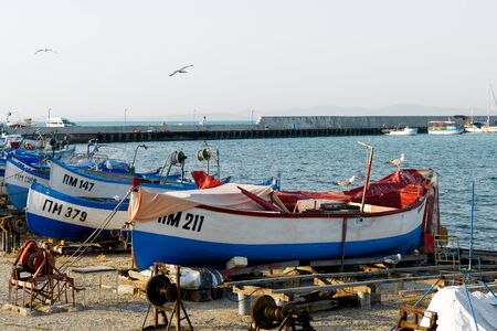 Pomorie, Bulgaria - July 02, 2017: Row of white and blue wooden fishing boats moored at the harbor of Pomorieのeditorial素材