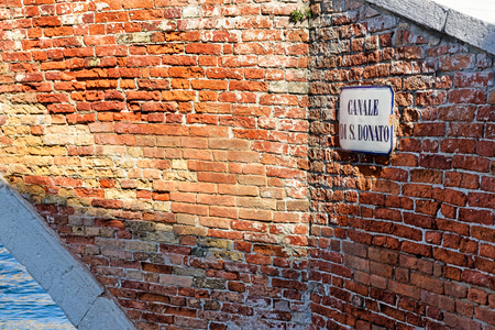 Canale di San Donato road name sign on red brick wall, Murano island, Venice, Italyの写真素材
