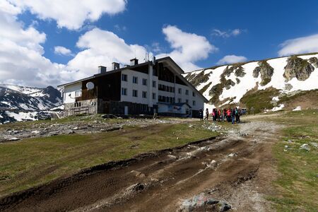 Rila mountains, Bulgaria - May 20, 2017: Rilski Ezera hut on the tourist route to Seven Rilski Ezera place and group of hiker gather in frontのeditorial素材
