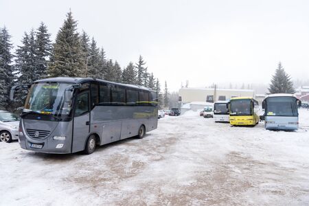 Vitosha, Bulgaria - March 03, 2018: Multiple buses parked on snow covered parking in the mountains with spruce trees forest in backgroundのeditorial素材
