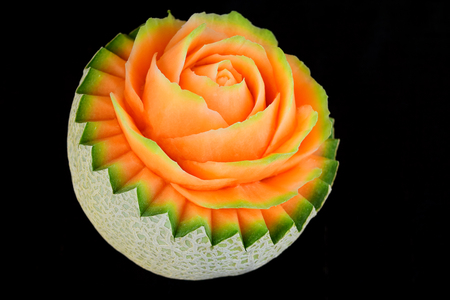Juicy carving and half cut honeydew melon isolated on black backgroundの写真素材