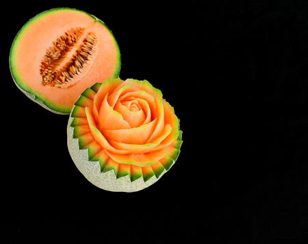 Juicy carving and half cut honeydew melon isolated on black backgroundの写真素材