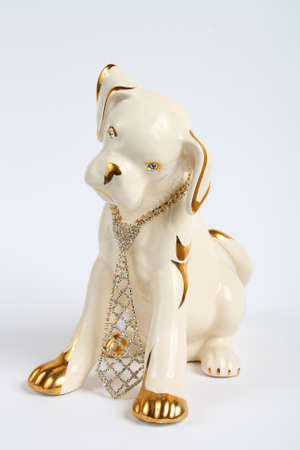 Statuette of a puppy with the jewelry on a white backgroundの写真素材