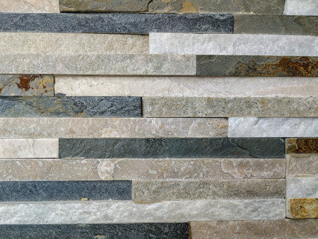Modern colorful good looking wall brick tiles made of rough purposely uneven solid stones as...