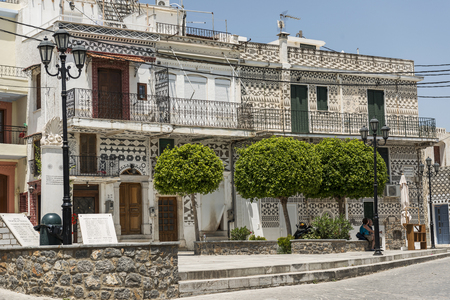 Village of Pyrgi - Chios Island.The houses of Pyrgi are very special, with geometrical patterns in shades of gray. One of the most famous medieval villages in Chios island.Here is one of the old streets Pyrgi and a native woman sitting in front of her houのeditorial素材