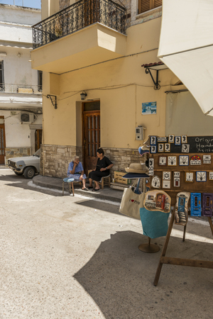 Village of Pyrgi - Chios Island.The houses of Pyrgi are very special, with geometrical patterns in shades of gray. One of the most famous medieval villages in Chios island.Here is one of the old streets Pyrgi and a native woman sitting in front of her houのeditorial素材