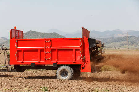Agricultural scene of farmer manure spreading as agricultural background. Fertilising the field.の写真素材