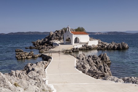 In North Chios and shortly after Sykiada village lies the picturesque chapel of Agios Isidoros (St. Isidore). It is a bay with beach with fine pebbles which leads to the chapel.  It is one of the most photographed places on the island. Behind the church tの写真素材
