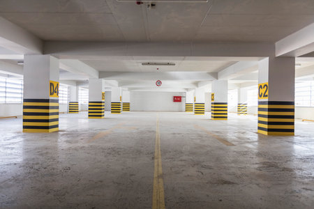 Interior of a parking garage with yellow and black warning signs.の写真素材
