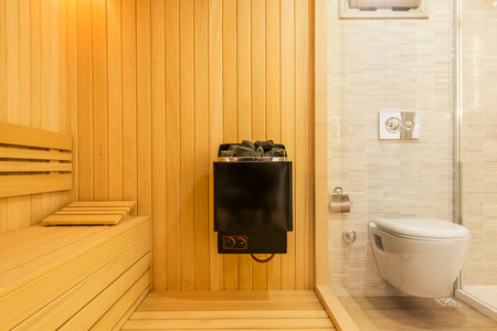Interior of a wooden sauna room with bathtub and toiletの写真素材