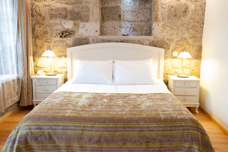 Interior of a hotel bedroom with a double bed and pillowsの写真素材