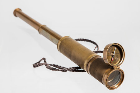 Old spyglass and compass isolated on white background with clipping path.