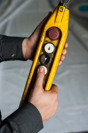 Close up of a hand holding a yellow spirit level in a construction site