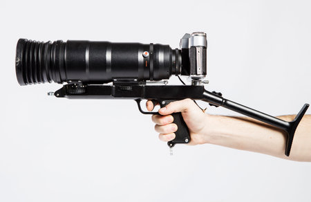 Camera in hand on a white background. Professional equipment for shooting.