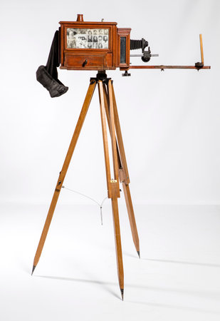 Old fashioned wooden photo camera on a tripod isolated on a white backgroundの写真素材
